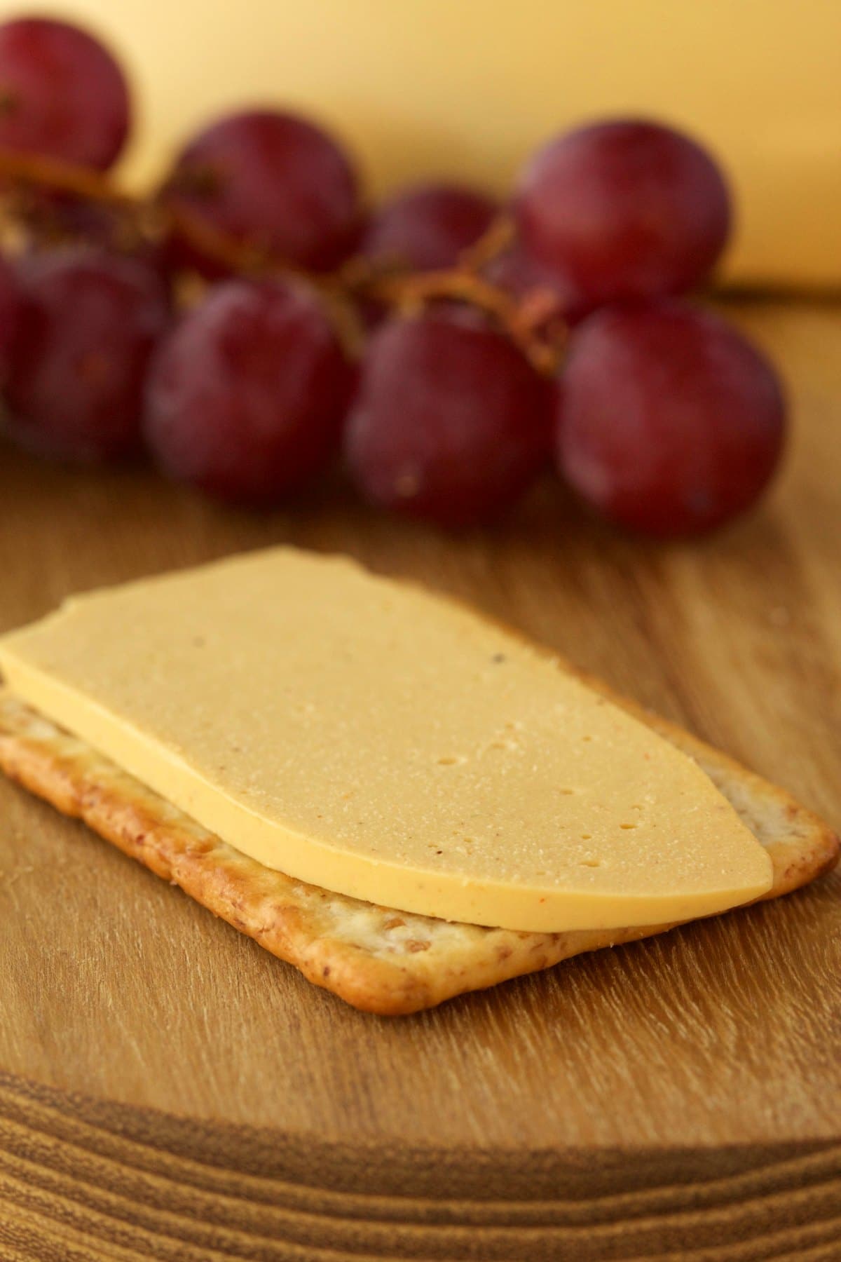 A slice of vegan cashew cheese on a cracker. 