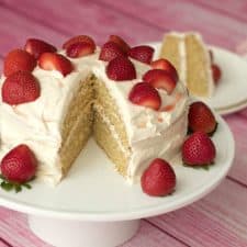 Vegan vanilla cake on a white cake stand.