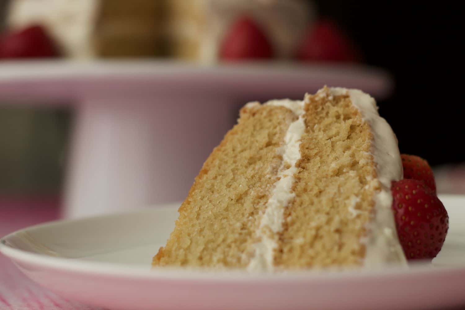 A slice of vegan vanilla cake on a white plate. 