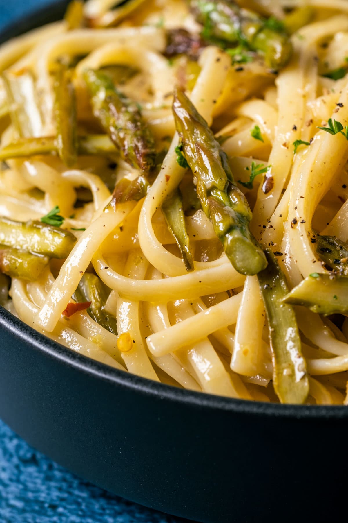 Asparagus pasta in a black bowl.