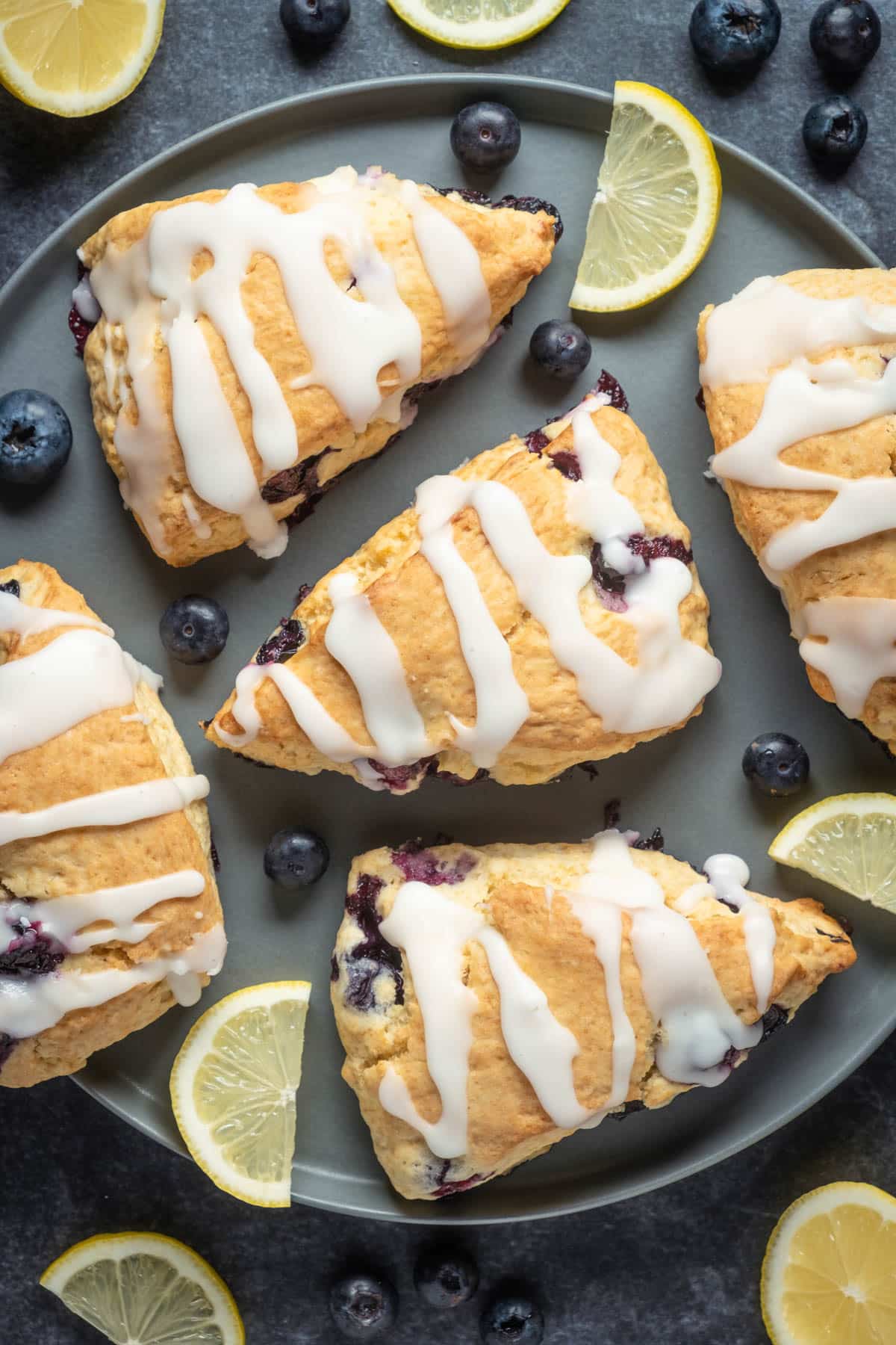 Glazed blueberry scones on a gray plate. 