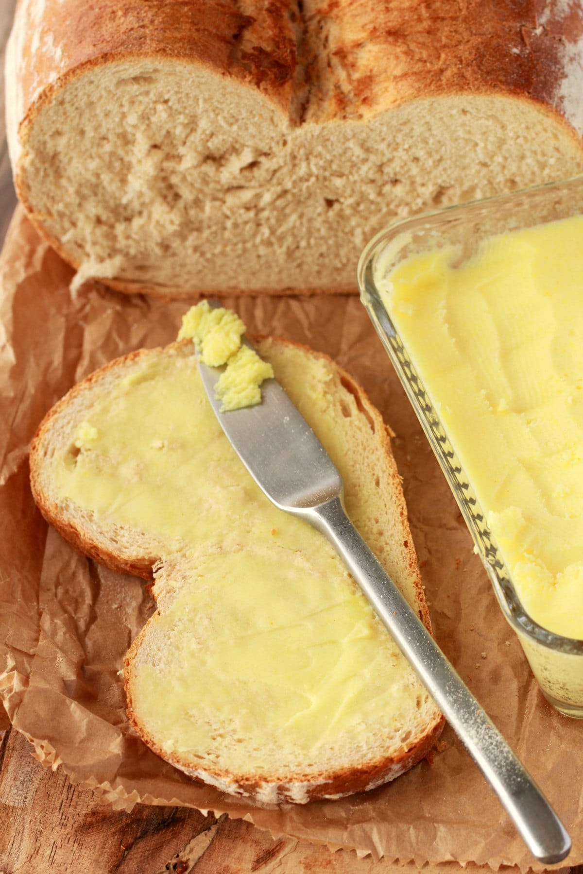 Vegan butter spread on a slice of bread with a butter knife. 