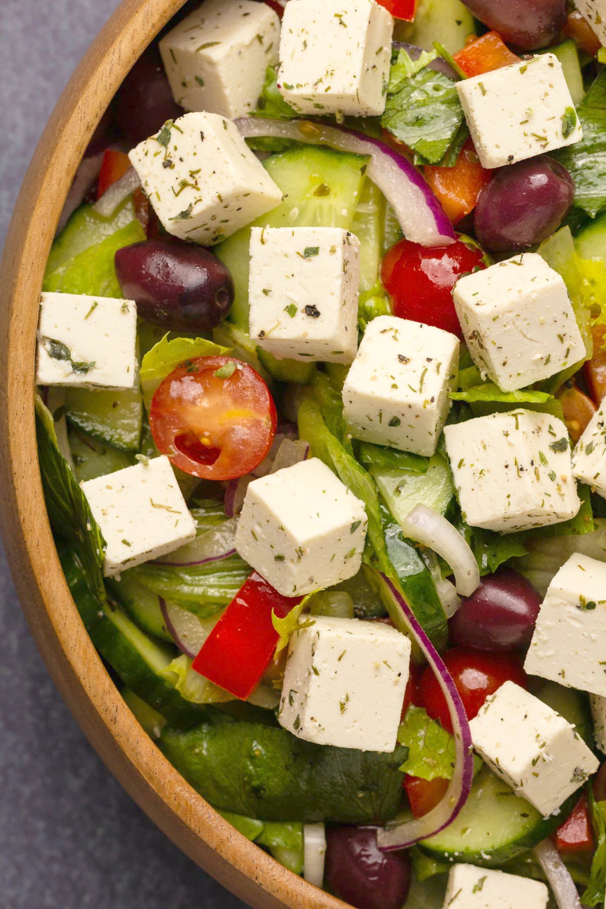 Vegan feta with oregano and dill on top of a Greek salad. 