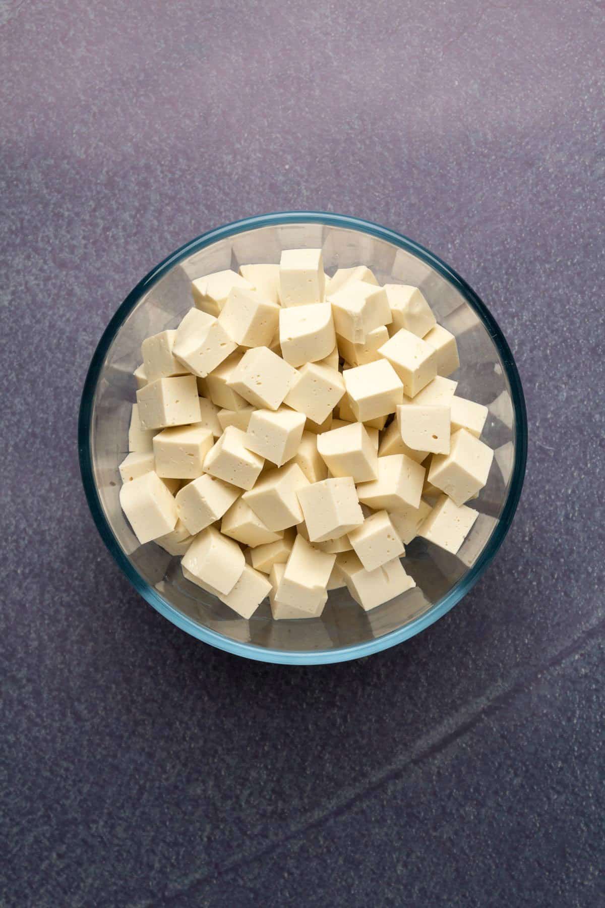 Cubes of vegan feta in a glass dish.