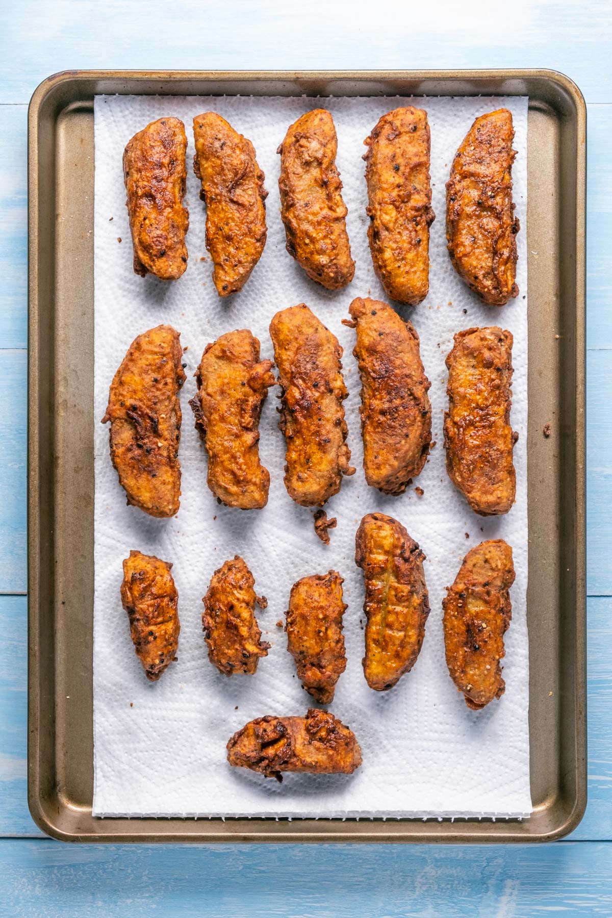 Vegan fried chicken pieces on a baking sheet lined with paper towels.