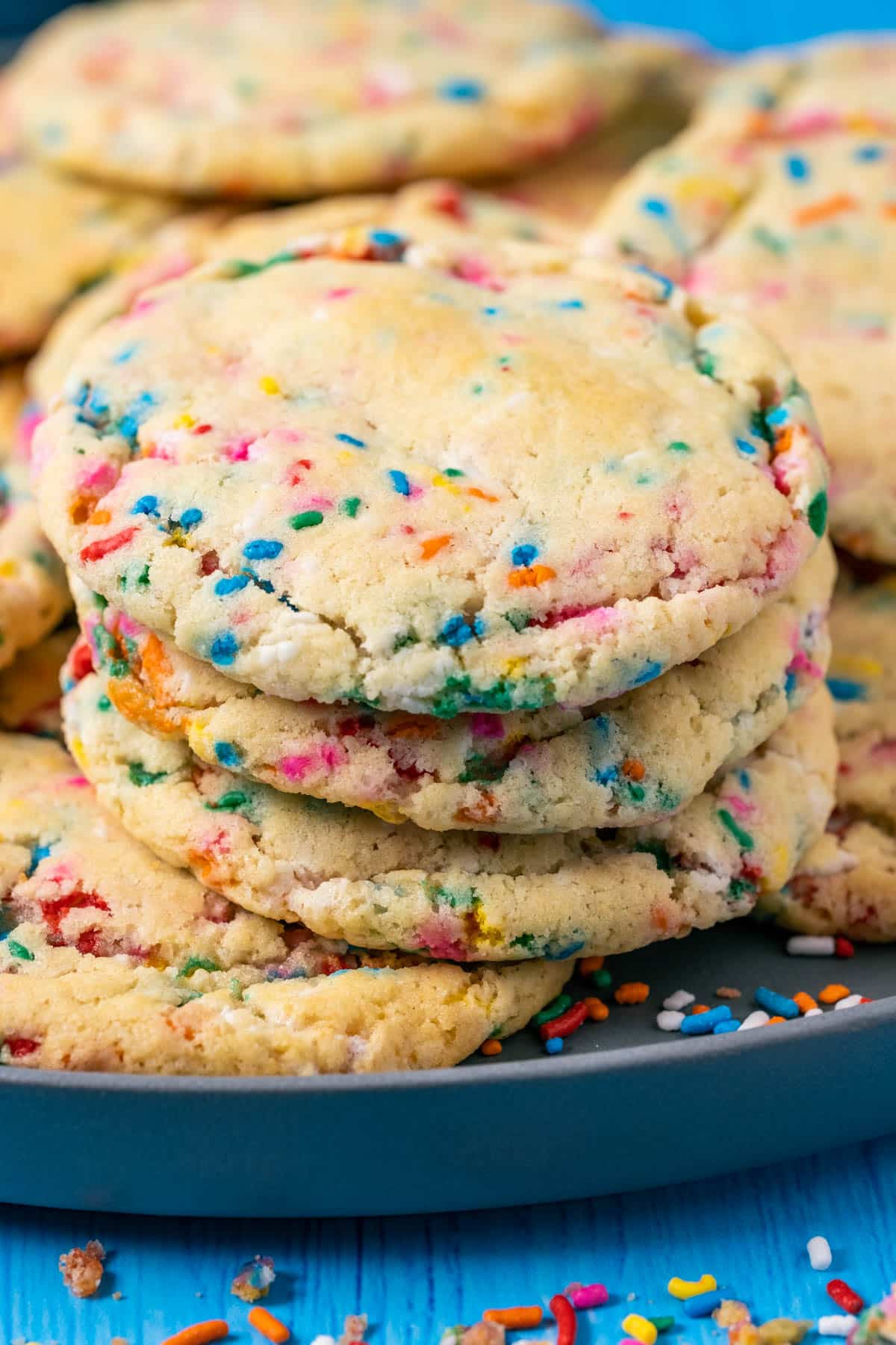 Vegan funfetti cookies stacked on a gray plate.