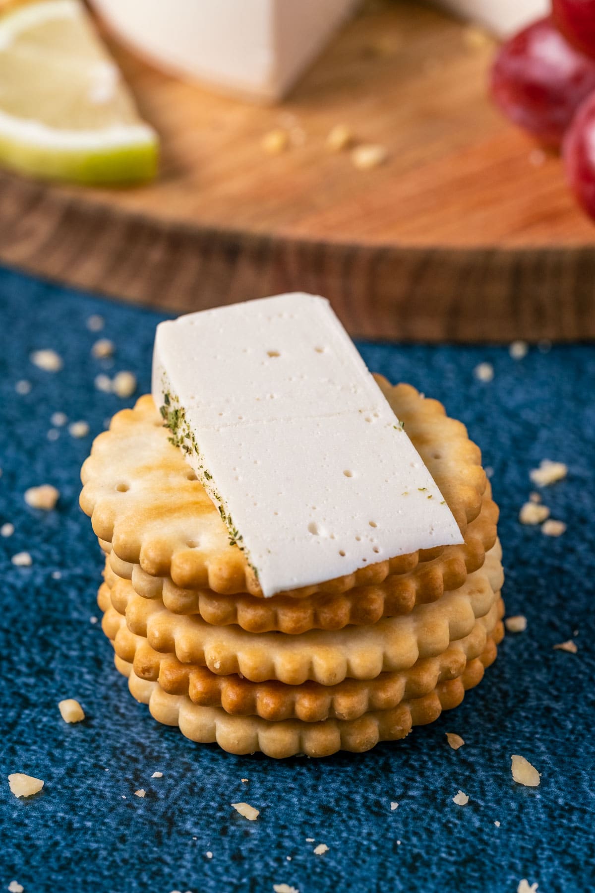 Slice of vegan goat cheese on a stack of crackers.