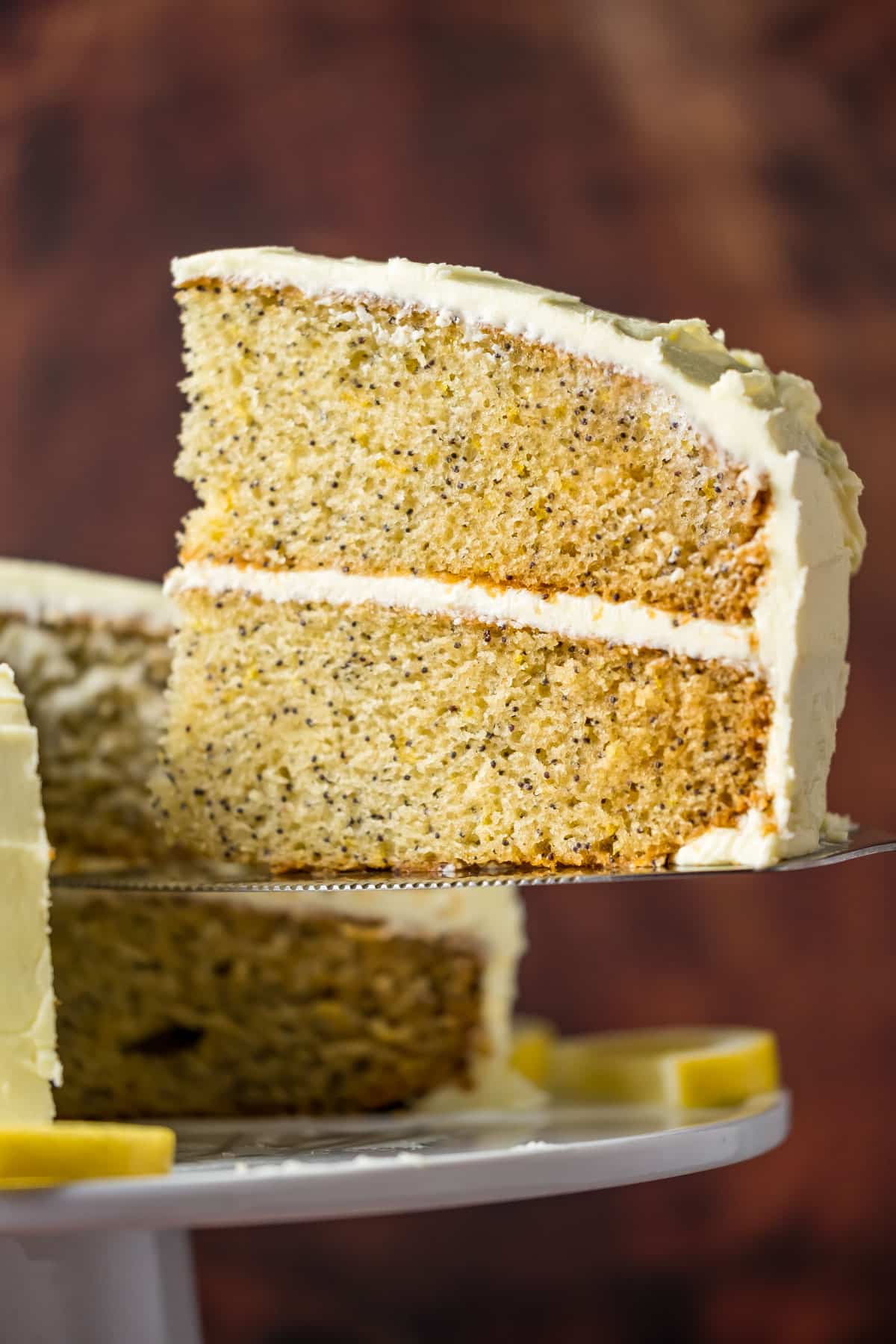 Slice of vegan lemon poppy seed cake on a cake lifter.