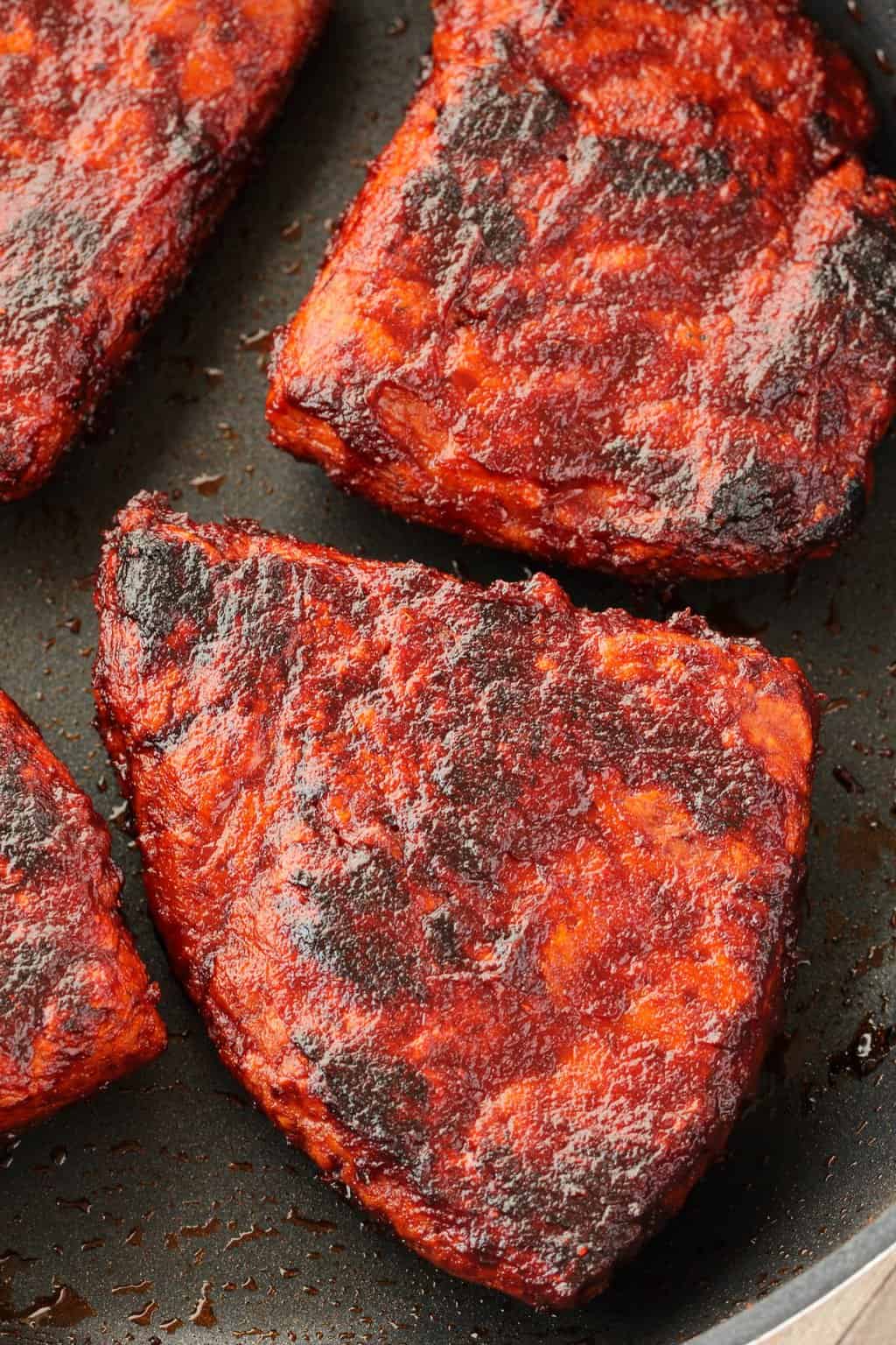 Vegan Steaks nicely charred and browned in a frying pan. 