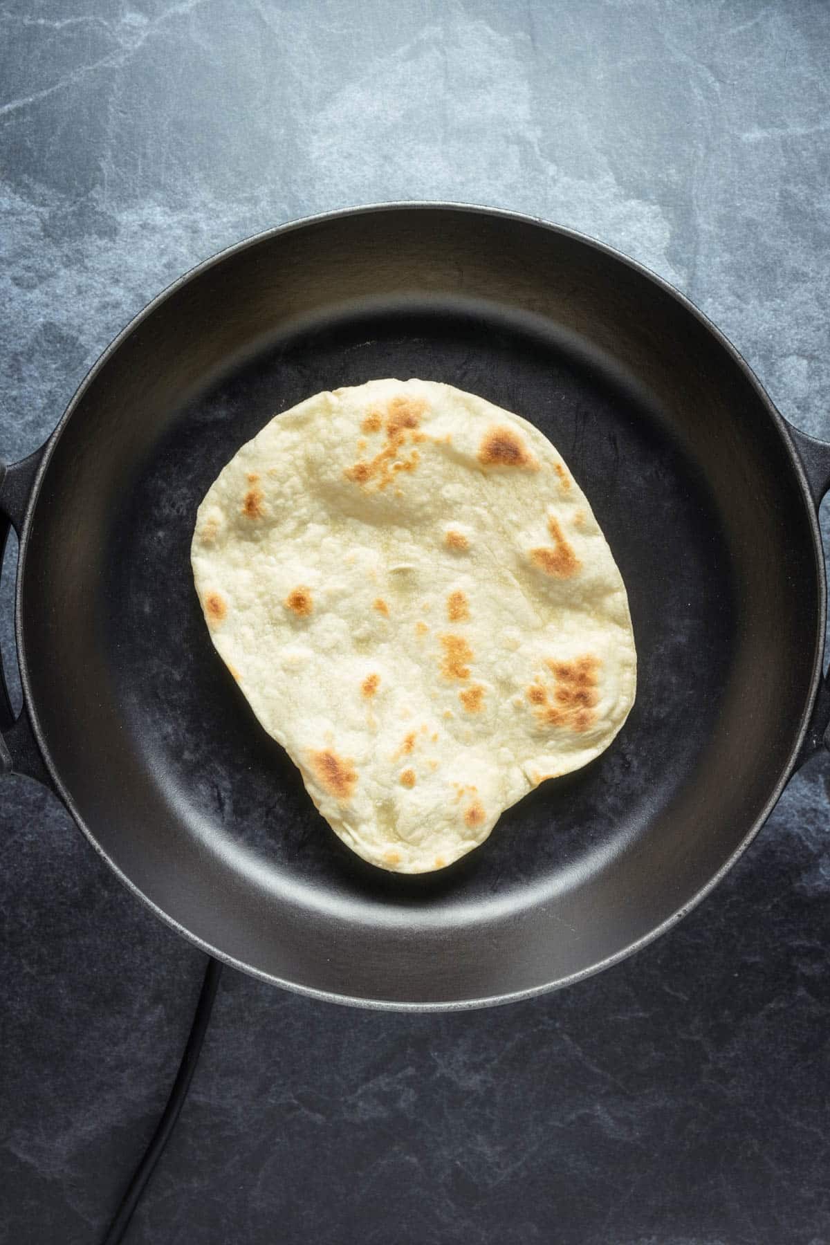 Tortilla cooking in a skillet. 