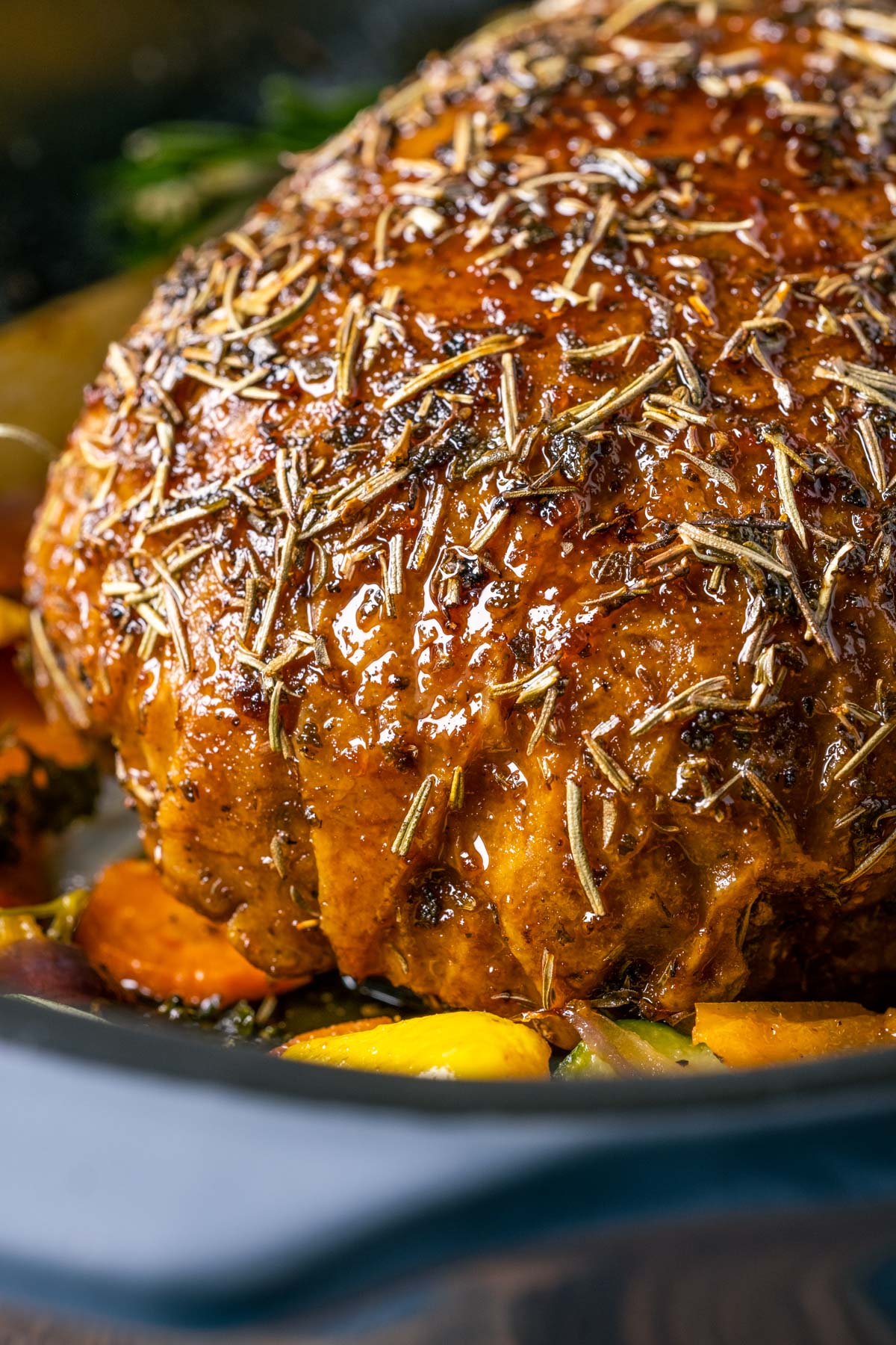 Vegan turkey roast in a roasting pan with vegetables.